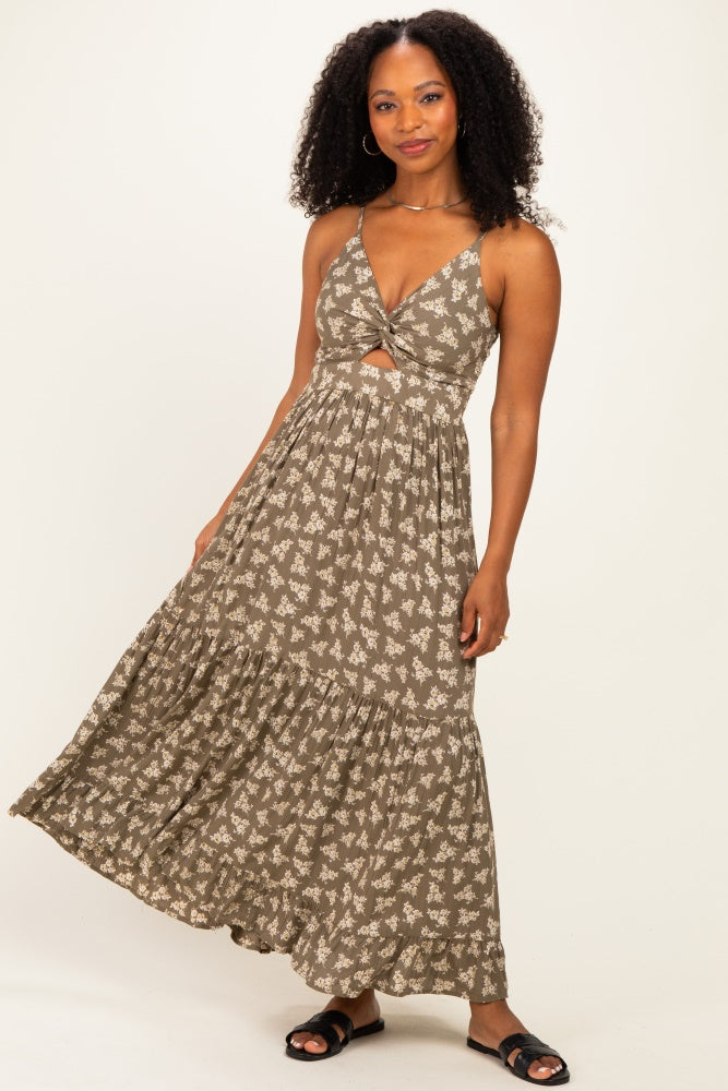 woman wearing a brown floral maxi dress with a front knot and ruffled hem, standing confidently