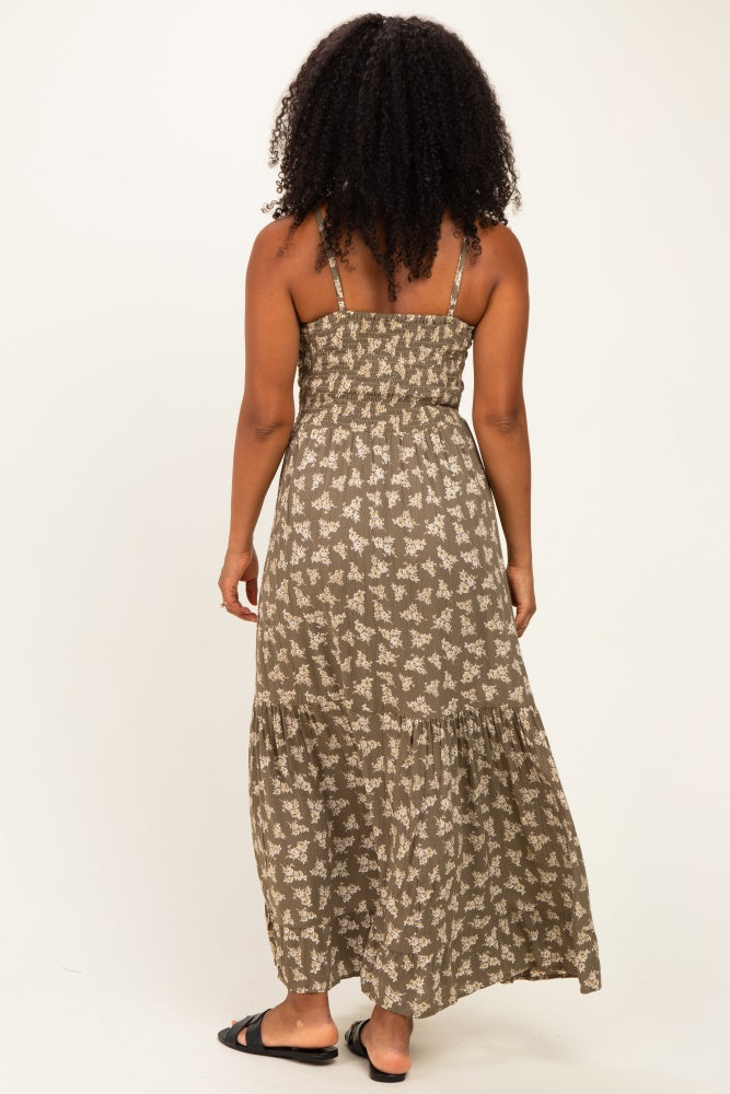 woman wearing a brown floral maxi dress with thin straps and a tiered hem, showing the back view