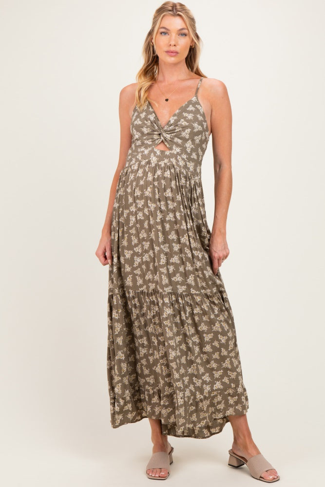 woman wearing a floral olive green maternity maxi dress with a knot detail and a visible baby bump