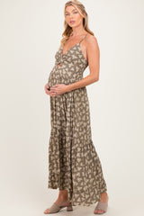 woman wearing a brown floral maternity maxi dress and cradling her baby bump