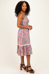 woman wearing a floral print sleeveless dress with ruffled hem and block heel sandals