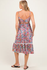 woman wearing a floral print maternity dress with a tiered skirt and adjustable straps, showing off her baby bump from the back
