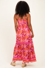 woman wearing a pink floral maxi dress with a tiered hem and spaghetti straps, seen from the back
