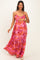 woman wearing a pink floral maxi maternity dress and holding her baby bump