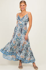 woman wearing a blue and white floral maxi dress with adjustable straps and a flowing skirt