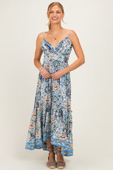woman wearing a floral maxi dress with adjustable straps and a flowy hemline, smiling at the camera