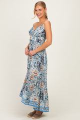 woman wearing a floral maxi dress with spaghetti straps and a flared hem, smiling and standing sideways