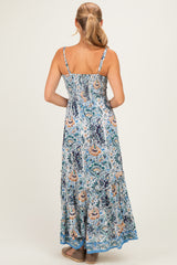 woman wearing a floral print maxi dress with a smocked bodice and tiered skirt, showing the back view
