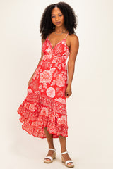 woman wearing a red floral print midi dress with spaghetti straps and a ruffled hem