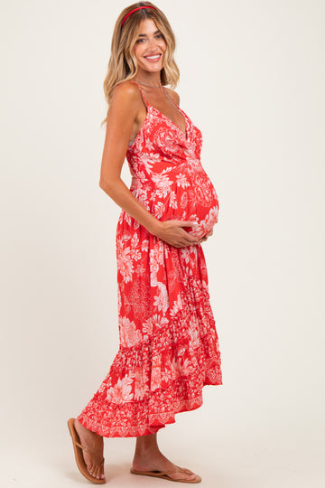 woman wearing a red floral maternity maxi dress and holding her baby bump
