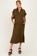 woman wearing an olive green short sleeve maternity dress with a collar, side slits, and pockets, holding a handbag