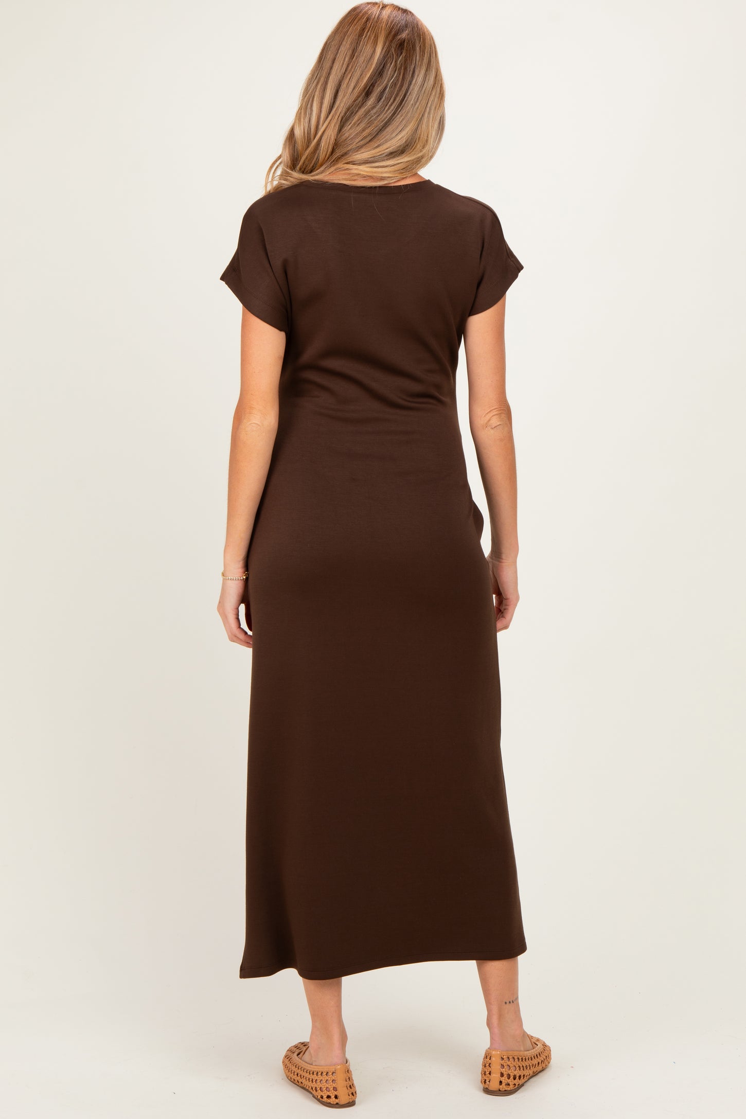 woman wearing a brown maternity maxi dress, shown from the back, with short sleeves and a relaxed fit