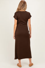 woman wearing a brown maternity maxi dress, shown from the back, with short sleeves and a relaxed fit
