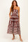 woman wearing a strapless brown and white printed maxi dress with pockets and a flowy silhouette