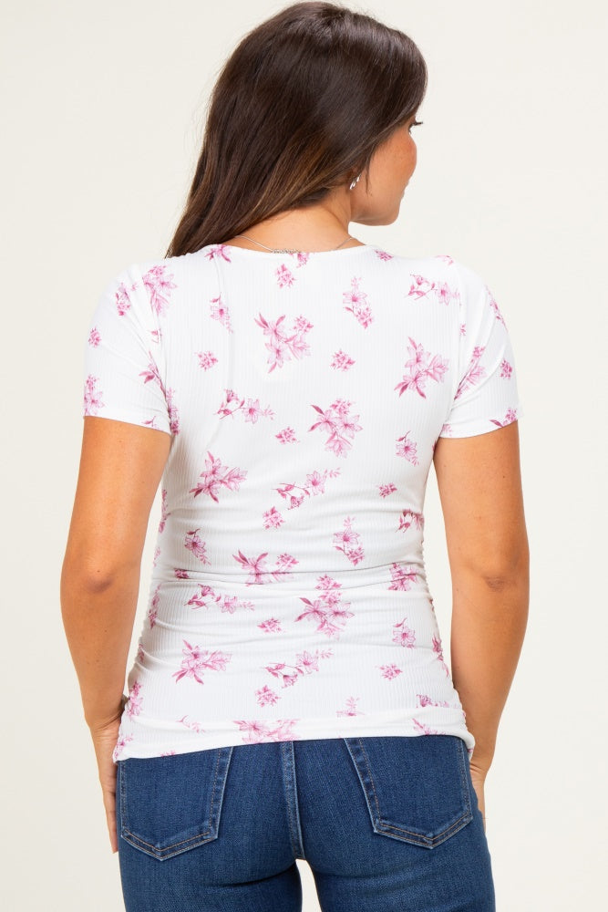 woman wearing a white maternity top with pink floral print and short sleeves, showing a fitted style from the back