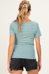woman wearing a light teal striped maternity top with short sleeves and a fitted style, showing her back