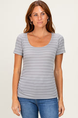 woman wearing a gray striped short sleeve top with a scoop neckline and denim jeans