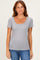 woman wearing a gray striped short sleeve top with a scoop neckline and denim jeans