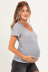 woman wearing a gray and white striped maternity top, showing her baby bump with a relaxed fit