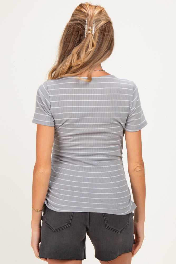 woman wearing a gray striped maternity top seen from the back, with a fitted style and short sleeves