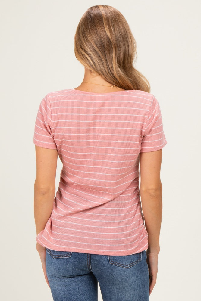 woman wearing a pink striped short sleeve top, viewed from the back.