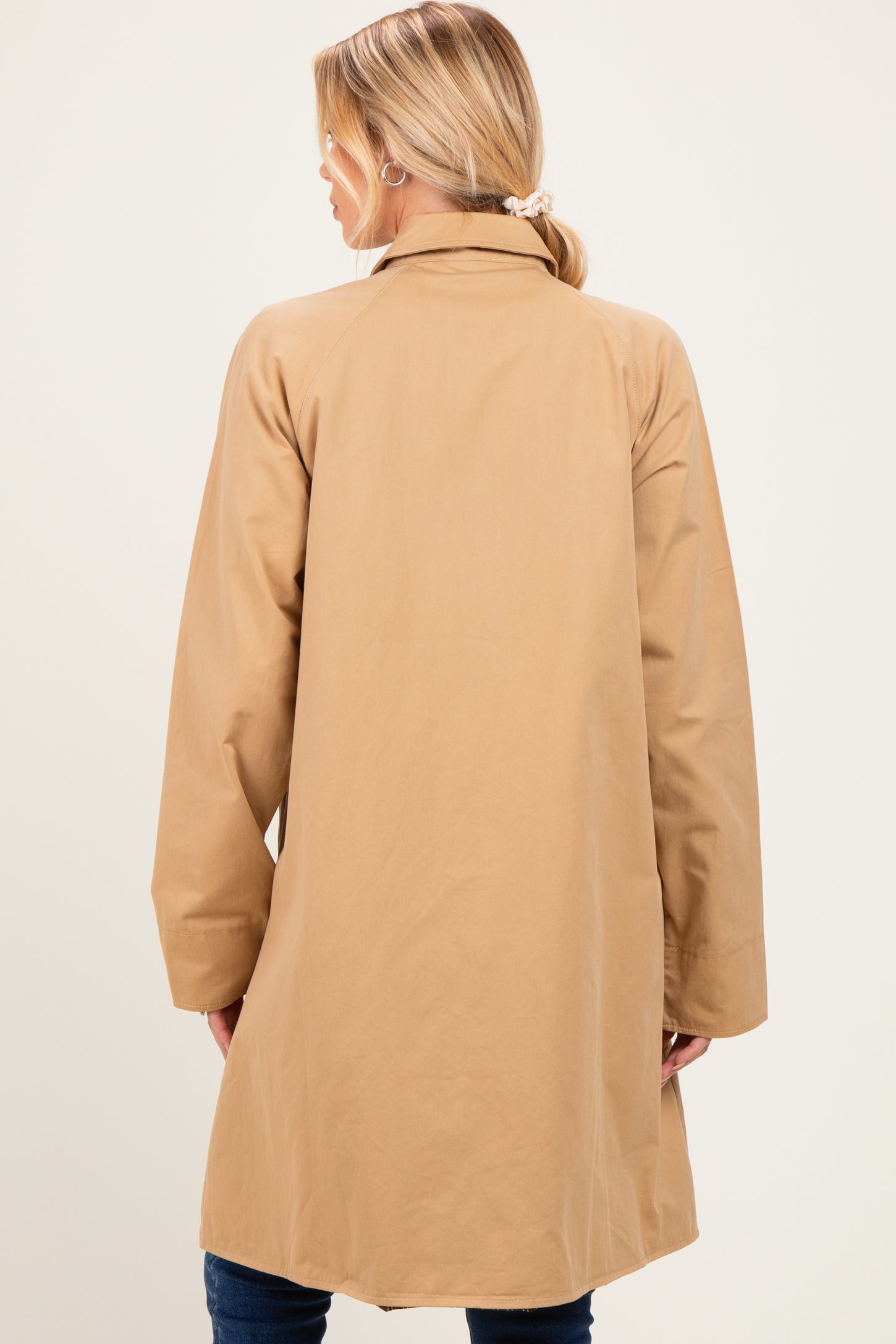 woman wearing a tan maternity coat, viewed from the back