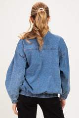 woman wearing a blue oversized denim maternity jacket with elasticized hem and balloon sleeves, showing her back