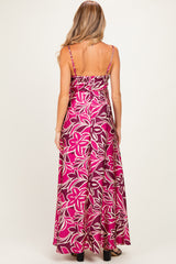 woman wearing a pink floral maxi maternity dress, showing the back with spaghetti straps