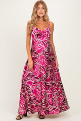 woman wearing a pink floral maternity maxi dress with a scoop neckline and adjustable straps, showcasing her baby bump