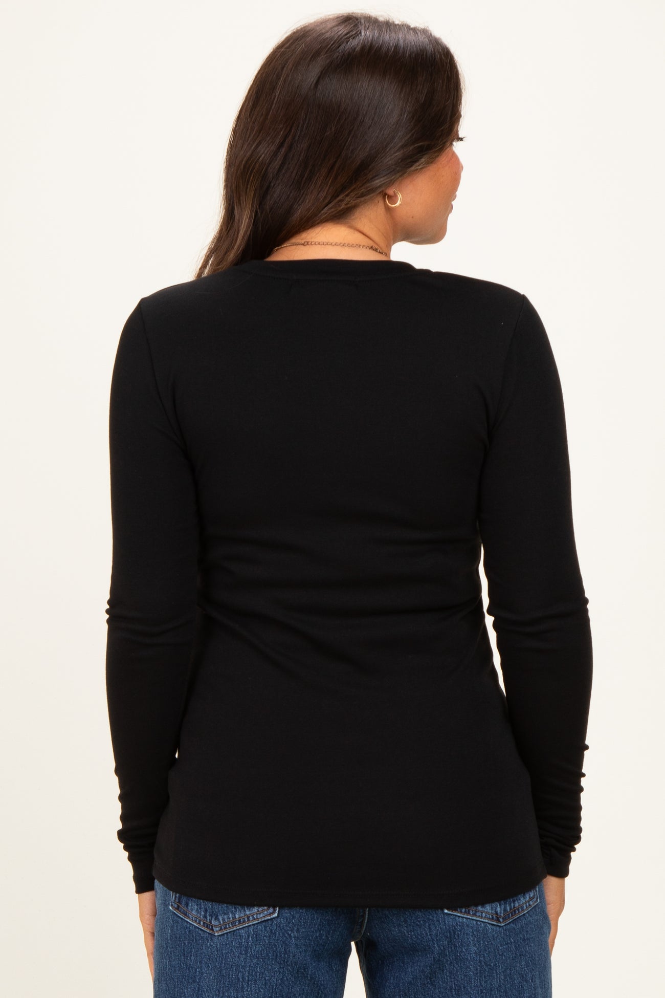 woman wearing a black long sleeve maternity top, view from the back