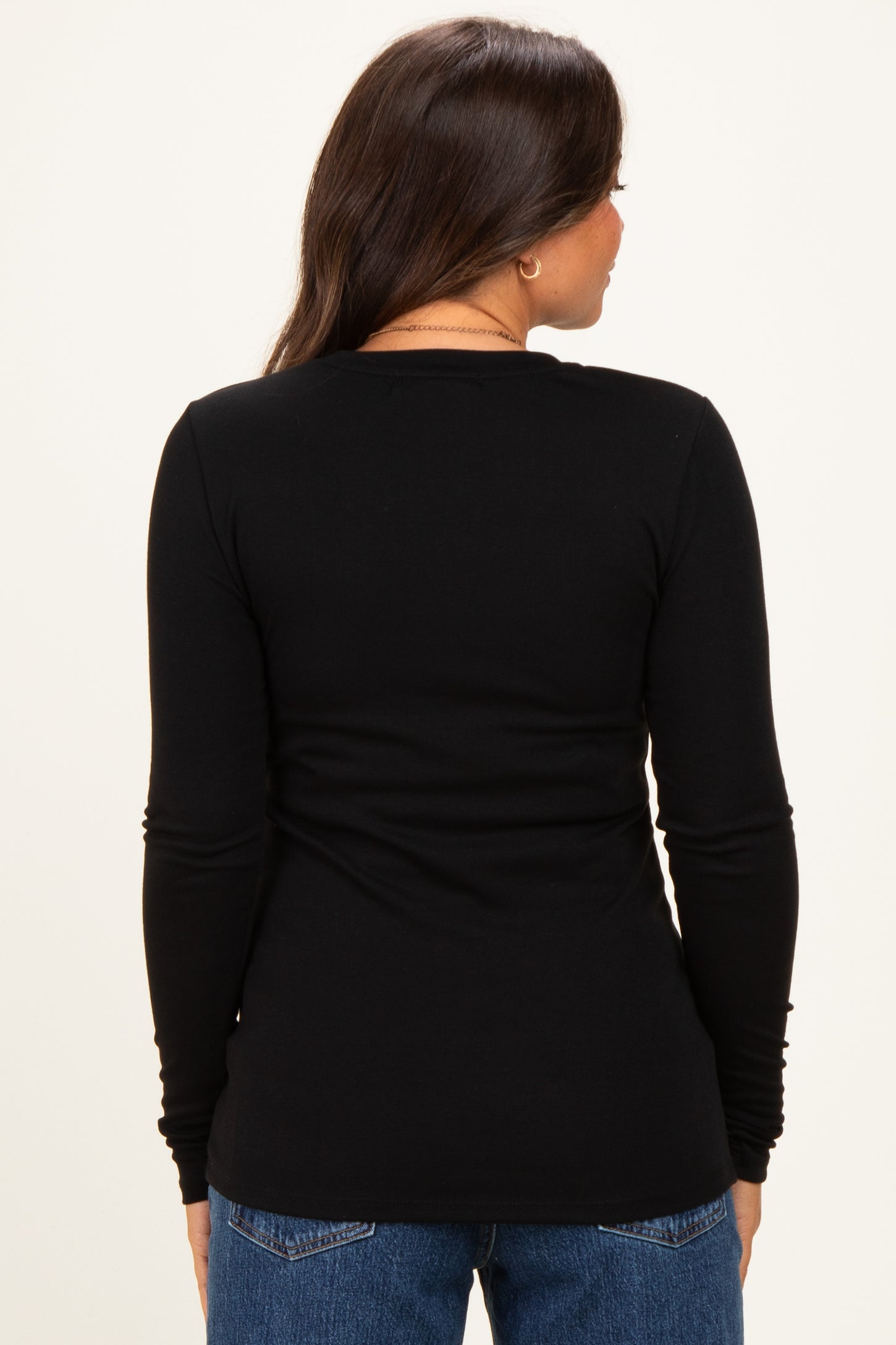 woman wearing a black long sleeve maternity top, view from the back