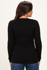 woman wearing a black long sleeve maternity top, view from the back