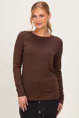 woman wearing a brown long sleeve top with a classic round neckline and a relaxed fit