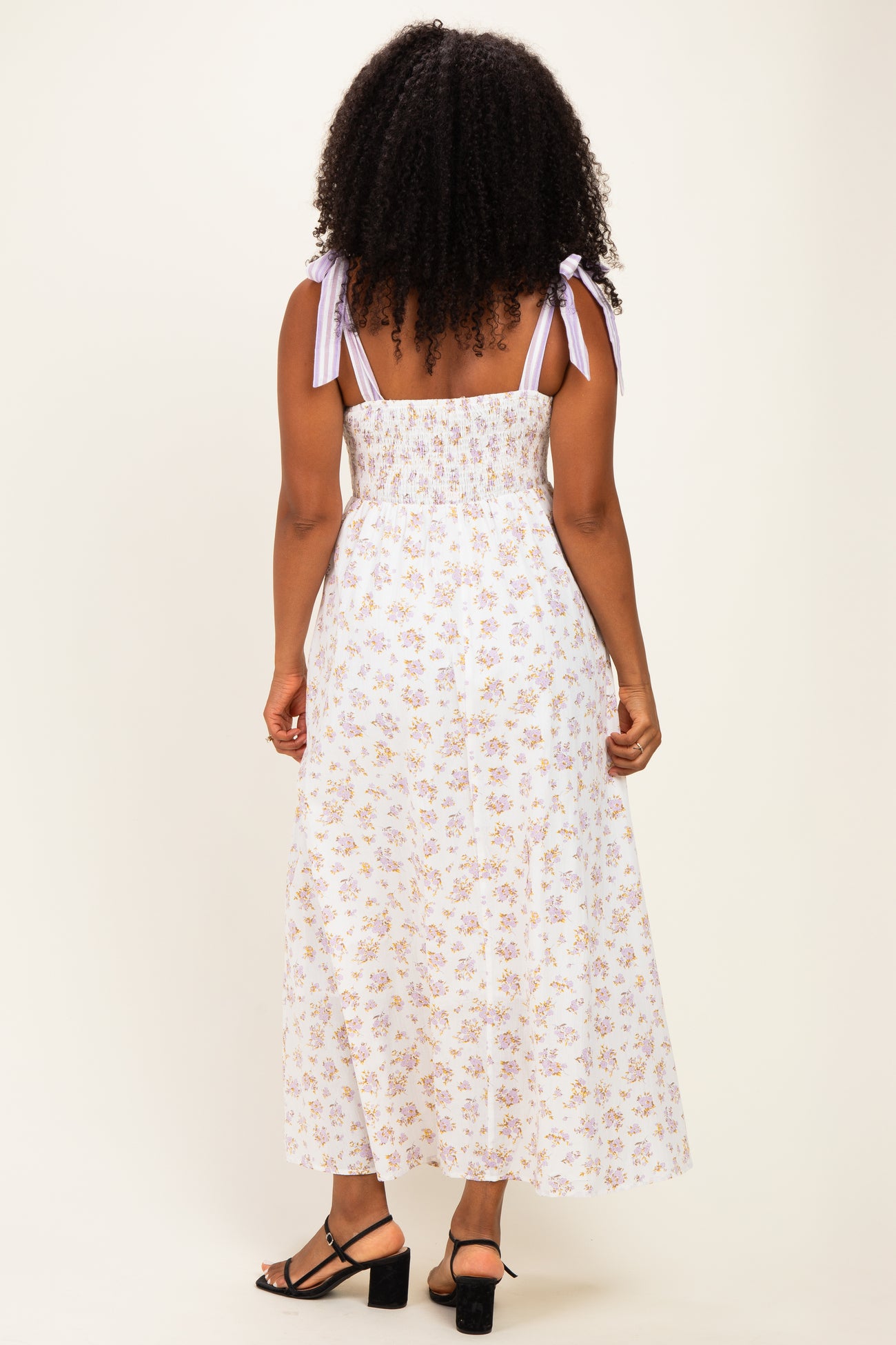 woman wearing a floral print maxi dress with back smocked detail and tied shoulder straps