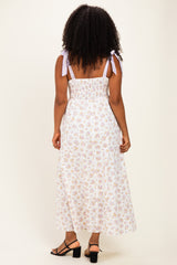 woman wearing a floral print maxi dress with back smocked detail and tied shoulder straps