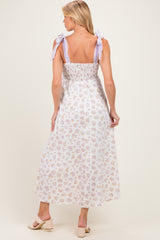 woman wearing a floral print maternity maxi dress with lavender tie straps and a smocked back, showing a baby bump