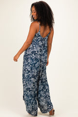 woman wearing a navy blue floral print jumpsuit with a relaxed fit and open back detail
