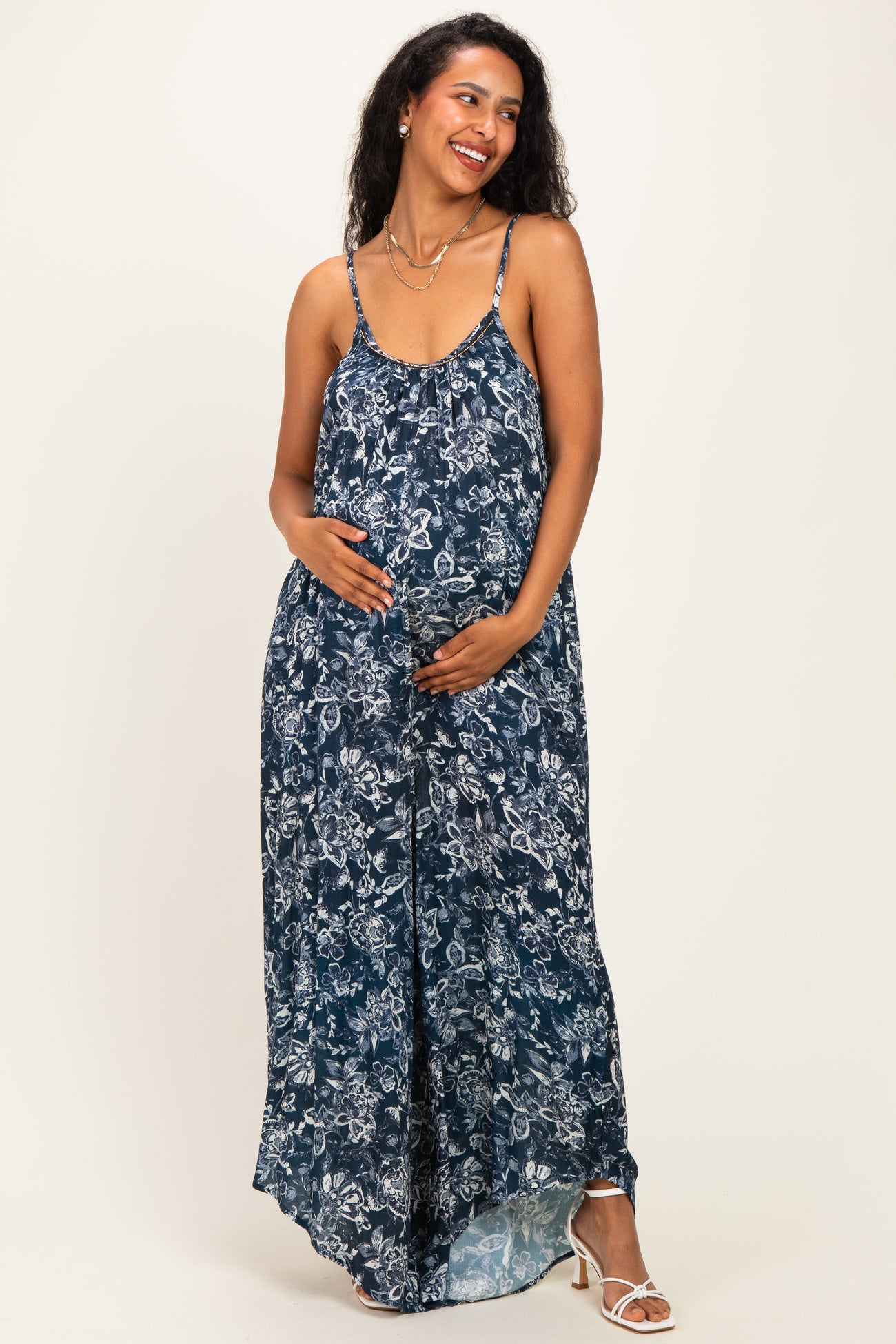woman wearing a navy blue floral maternity maxi dress and holding her baby bump