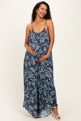 woman wearing a navy blue floral maternity maxi dress and holding her baby bump