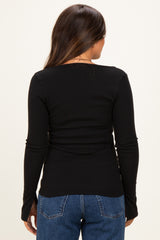 woman wearing a black long sleeve maternity top, showing the back view with a fitted style and ribbed texture