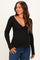 woman wearing a black long sleeve maternity top with a deep v-neck and a visible baby bump