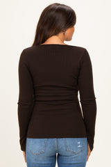 woman wearing a black long sleeve maternity top, showing the back view and paired with blue jeans
