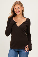 woman wearing a brown long sleeve wrap top with a v-neckline and bell sleeves, styled with blue jeans