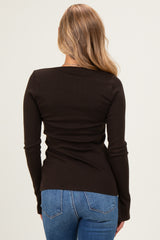 woman wearing a fitted black long sleeve top and blue jeans, viewed from the back