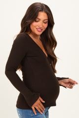 woman wearing a brown long sleeve maternity top with a v-neck and bell sleeves, showcasing her baby bump