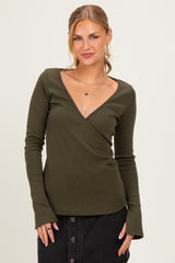 woman wearing an olive green long sleeve wrap top with a deep v-neck and fitted style