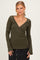 woman wearing an olive green long sleeve wrap top with a deep v-neck and fitted style