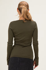 woman wearing a fitted dark green long sleeve top with ribbed texture, viewed from the back
