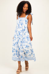 woman wearing a blue and white floral maxi dress with tie straps and a relaxed fit