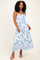 woman wearing a floral print blue and white maxi dress with adjustable straps and a smocked bodice